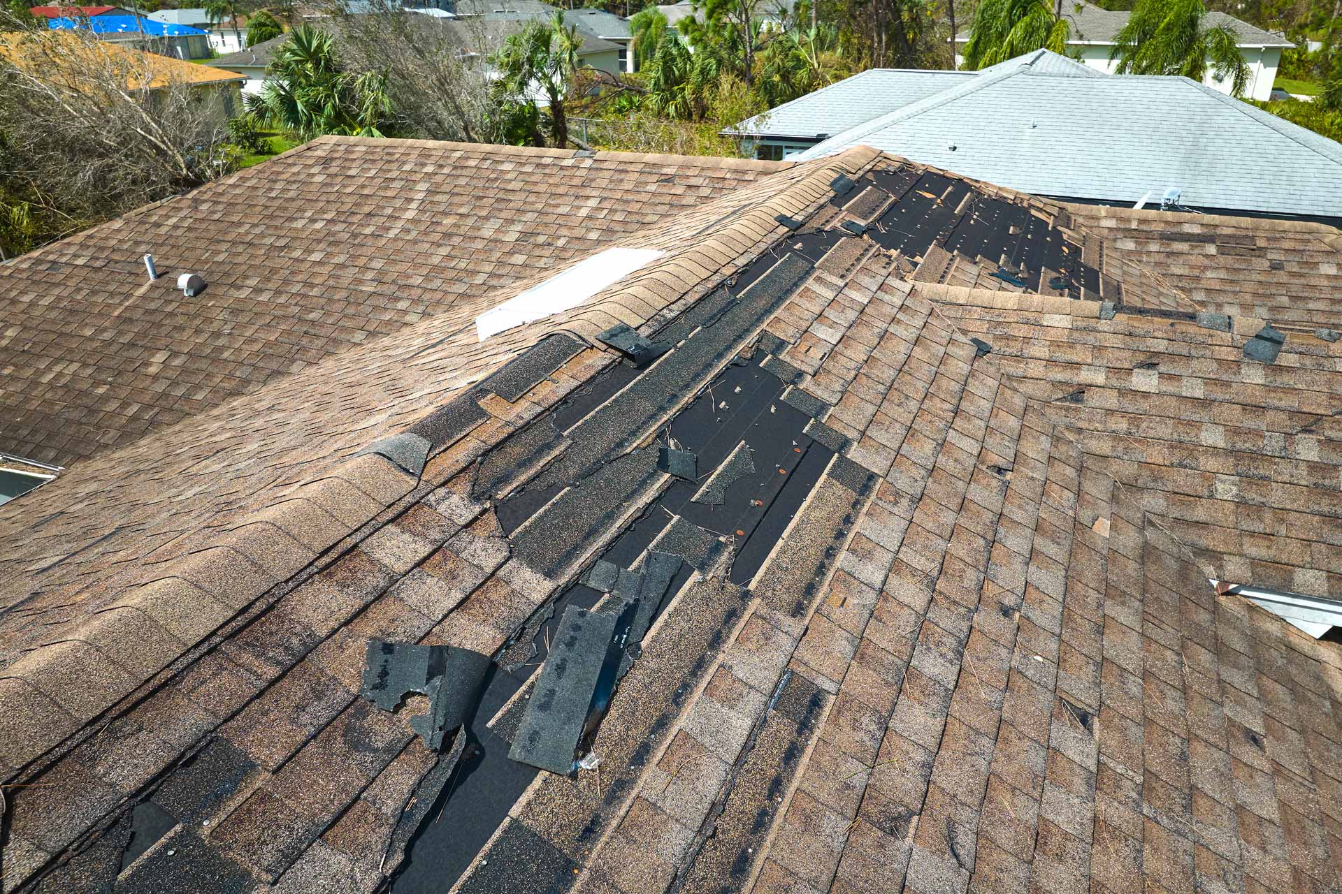 Asphalt shingle roof damaged by hurricane