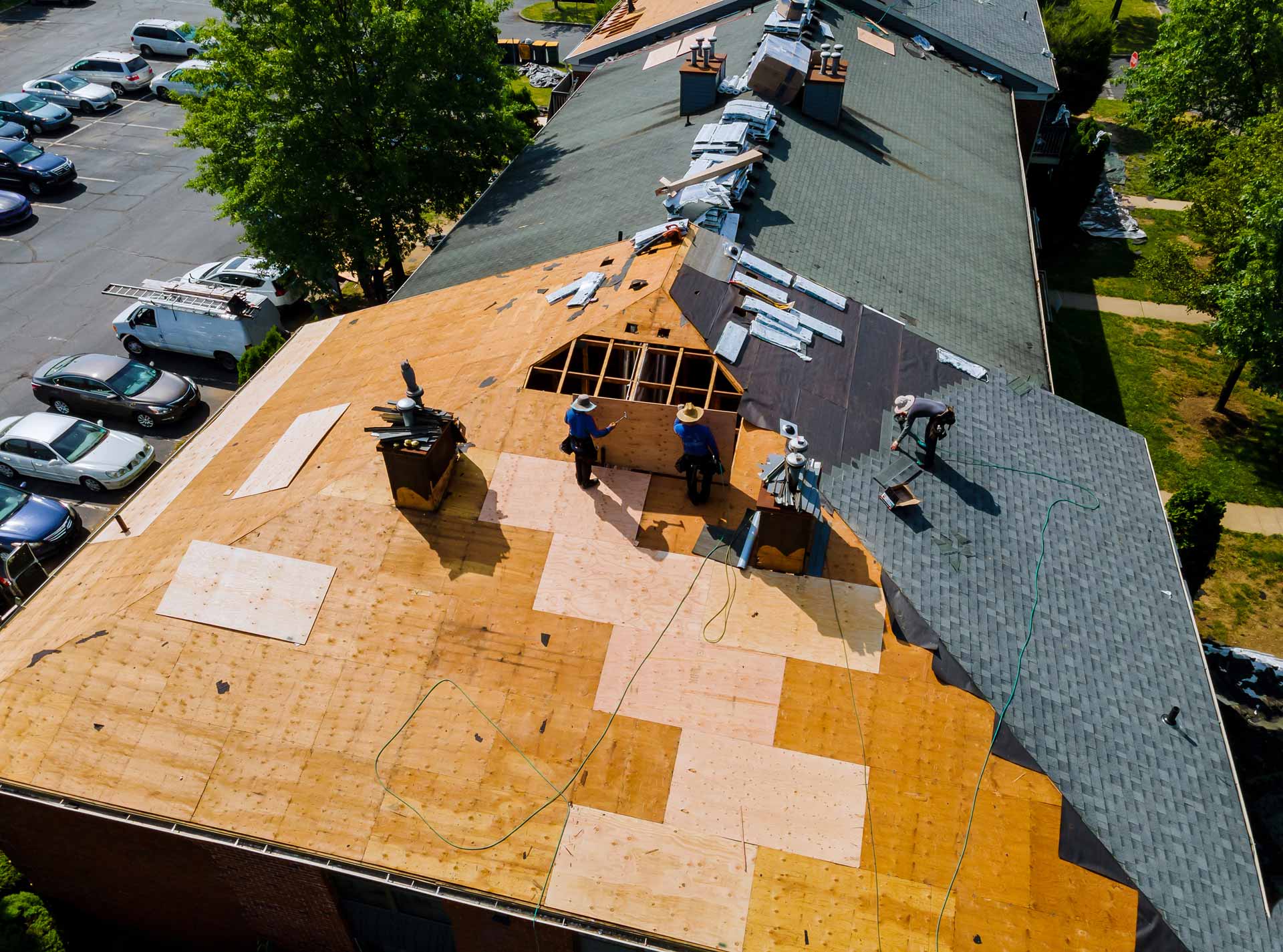 Roofing crew at work on large building