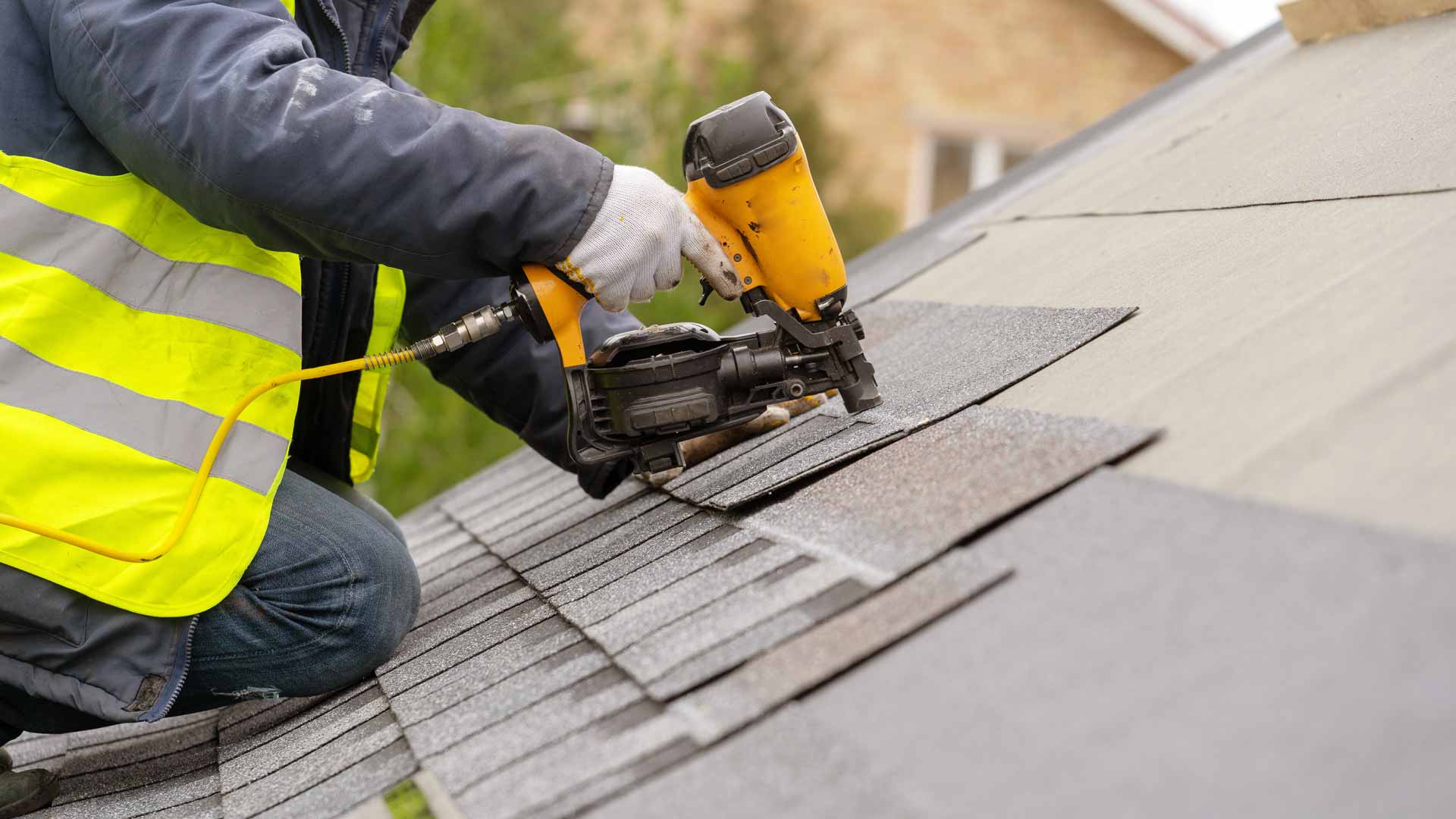 Roofer installing asphalt shingles on roof